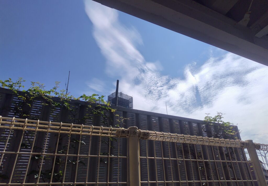 疾走感のある雲と青空とフェンス