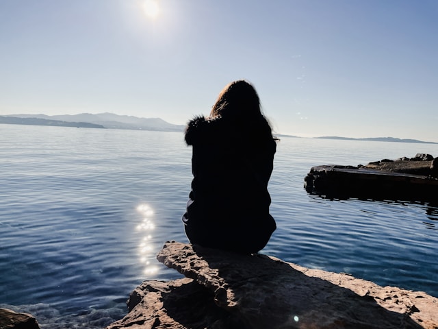 海を眺める女性の後ろ姿