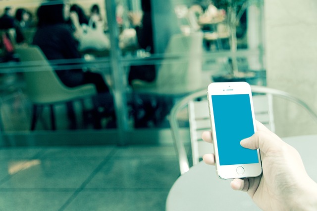 カフェのテーブルでスマホを触る手