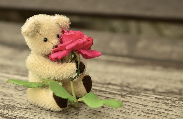 花を抱えた熊のぬいぐるみ