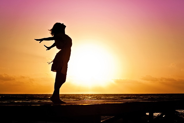 夕焼け空を背景にのびのびとしている女性のシルエット