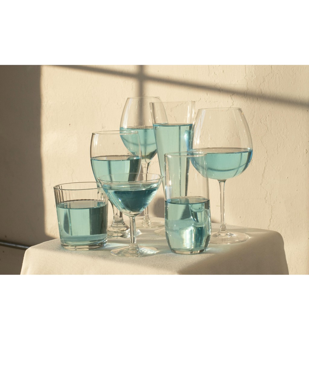 青い水が入ったいろんな形のグラス