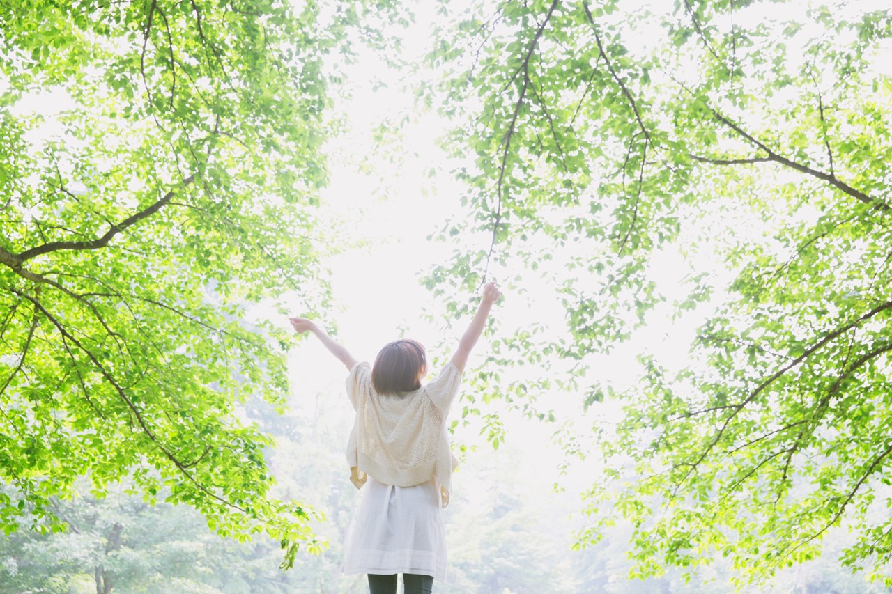 明るい自然の中でリラックスする女性
