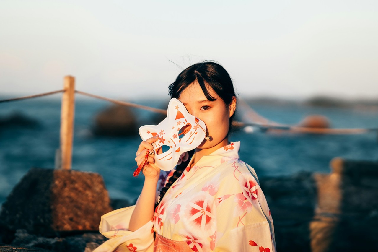 狐面を外す浴衣の女性
